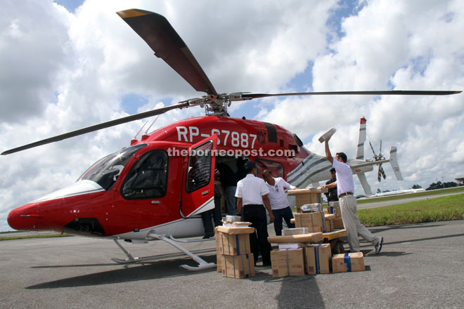 EC staff loading the last batch of ballot papers onto a helicopter at Hornbill Skyways yesterday. — Photo by Chimon Upon