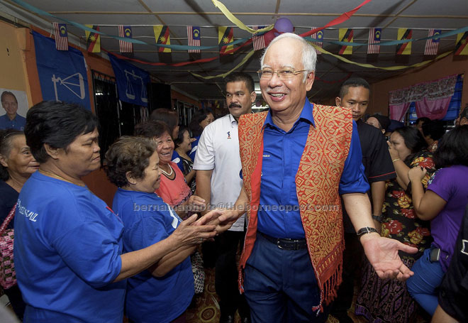 Najib happy to greet the welcoming crowd during his visit to Rh Faizal. — Bernama photos