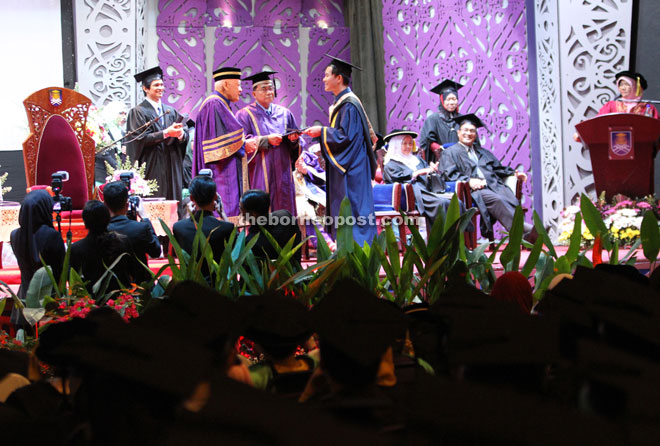 Arshad (left) presents the scroll to a graduate during UiTM’s 84th convocation ceremony. — Photos by Chimon Upon