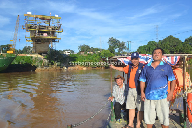 Yong, Sia and Ong cross Sungai Katibas on a ferry. In the background is the under-construction Katibas Bridge.