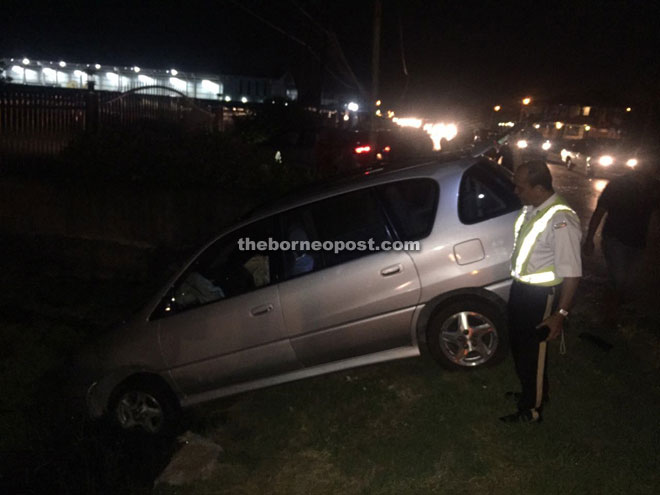 A policeman inspecting the crash scene at Jalan Tudan.