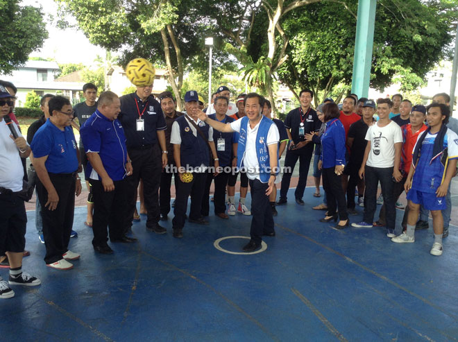 Hii eyes the takraw ball while showing his skills in the game before closing the competition at Piasau Jaya Phase 2 hall. Looking on are Chai and Lias (fourth and fifth left, respectively), together with others.