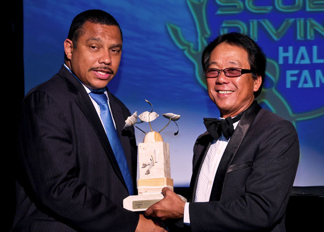 Clement Lee (right) receives the ISDHF Award from Cayman Island director of tourism. 