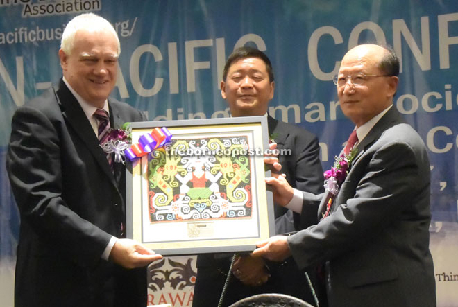Professor Jim (left) presenting a souvenir to Professor Lee, witnessed by Lai (middle). 