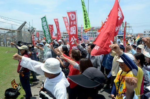 People raise their fists as they shout slogans to protest against the US military presence in front of the US Kadena Air Base in Cyatan, Okinawa prefecture, on May 21, 2016. AFP File Photo
