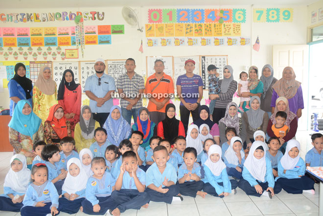 Nooreffariza (seated third left) and Nasir (fourth left in second row) pose with teachers and parents of Tabika Kemas Lakil C and D during the Teacher’s Day celebration.
