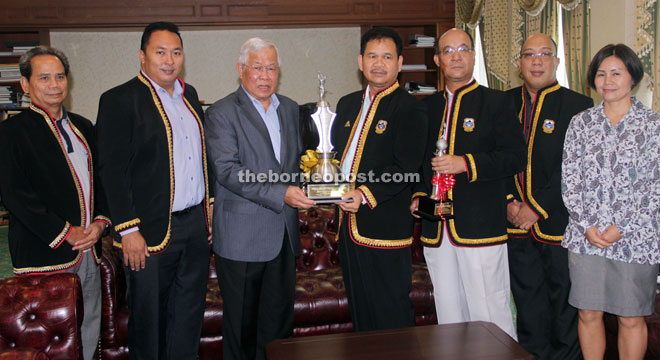 Ik Pahon (fourth right) receives the Dato Sri Michael Manyin Challenge Trophy from Manyin, as other committee members of the golf tournament look on.