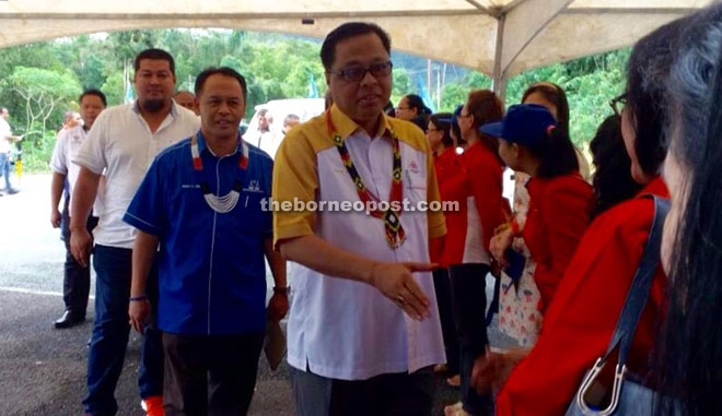 Henry (second left) leads Ismail Sabri to greet the villagers as they arrive at Tanjong Poting.