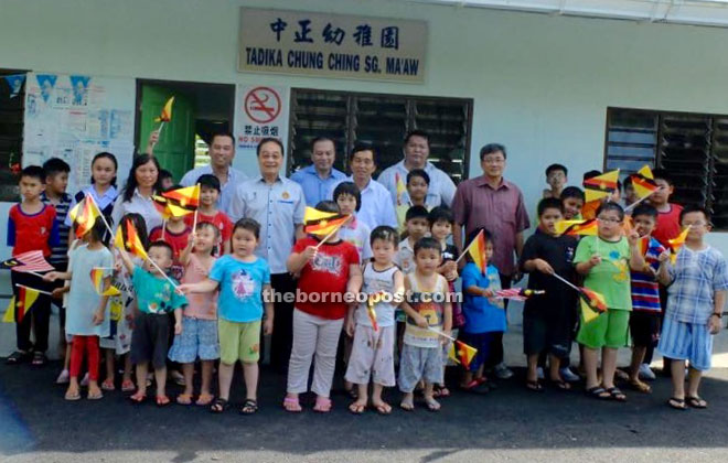 Wong shares some fun with these children by posing for a photo. 