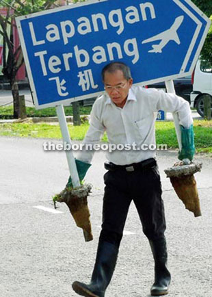 Flashback shows controversial activist Hii carrying a Sibu Airport road sign.