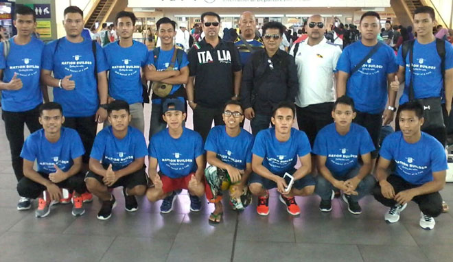 The state sepak takraw team members and officials posing with coach Sura Matawangsang (third right) at the Kuching International Airport before departing for Thailand on Wednesday.