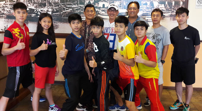Ho (second right, standing), Ng (right) and the athletes posing with (from left) Sarawak State Sports Council coordinator for wushu Thomas Chia, Allen Wong and James Ting.