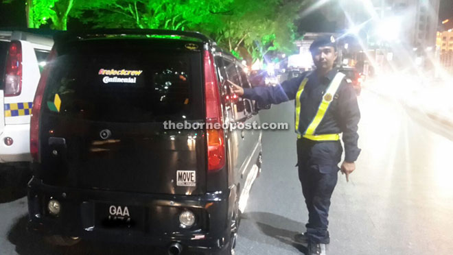 A JPJ team member points out the excessive tinted glass on a vehicle, which is an offence.