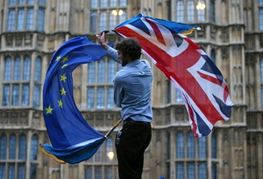 A man waves both a Union flag and a European flag on College Green outside The Houses of Parliament at an anti-Brexit protest in London on June 28, 2016. - AFP Photo