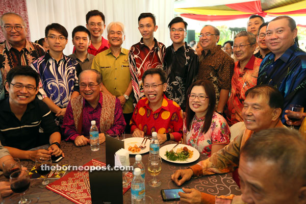 Dr Sim (seated third from left), his wife, Datin Enn Ong, and others at Uggah’s open house. Uggah is on Dr Sim’s right, while Ting is on Enn Ong’s left. 