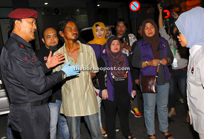 Fatimah listening to a briefing from an operation personnel on a vagabond picked up at Electra House area in Kuching.