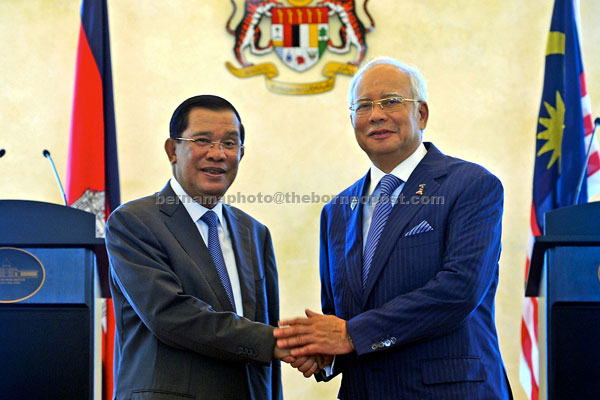 Najib (right) and Hun Sen greeting each other prior to the press conference. — Bernama photo