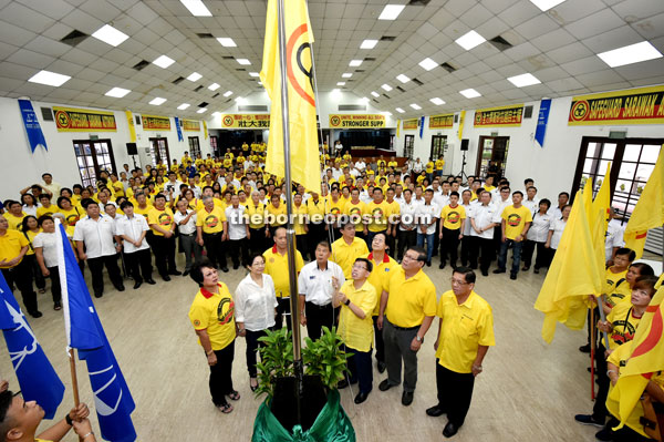 Dr Sim hoists the SUPP flag during the gathering. From front left are Chee, Yong, Ting, Harden, SUPP organising secretary Datuk Matthew Chen and Tan.