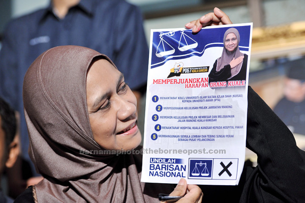 Mastura showing ‘Agenda Memperjuangkan Harapan Orang Kuale’ poster during a press conference at her house in Kuala Kangsar. — Bernama photo  