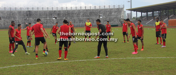 LATIHAN: Barisan pemain Sarawak memanaskan badan sebelum memulakan sesi latihan.