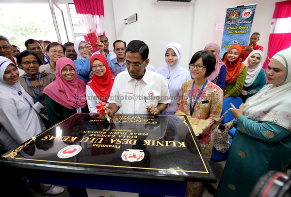 Dr Subramaniam signs a plaque to declare open the Ulu Kenas Rural Clinic. — Bernama photo