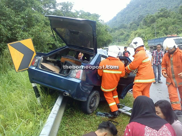 Firemen working to extricate the Iswara driver at the scene of the accident.