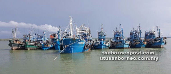 KERJA HARAM: Sebuah vesel induk asing yang berlabuh dan dihimpit lapan vesel nelayan C2 sedang melakukan kerja-kerja pemunggahan ikan antara vesel ke vesel.