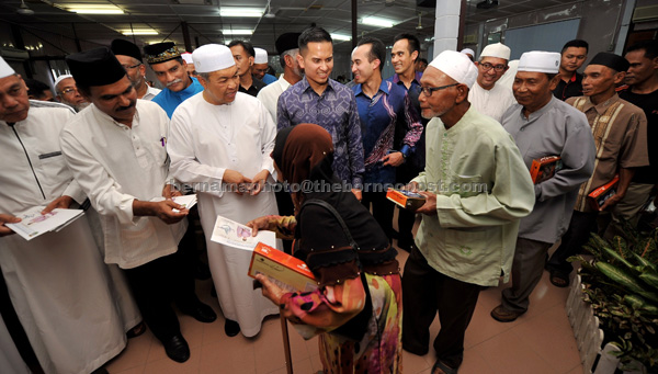 Ahmad Zahid (third left) handing over Ramadan contributions in Rungkup state constituency in Perak. — Bernama photo 