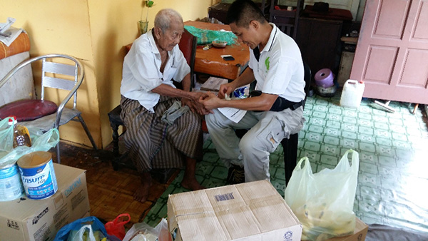 Kevin Wan takes Maree’s thumb print as an acknowledgement of receipt of the food items from Hope Place.