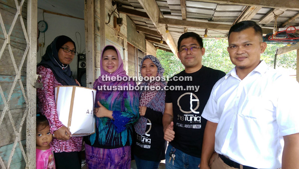 BANTU: Hasidah menyerahkan sumbangan kepada salah seorang penerima sambil disaksikan Mohd Alfian (dua kanan) dan Masliza (tiga kanan).