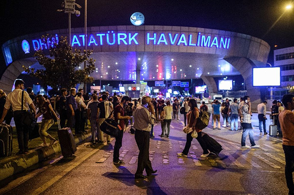 People stand outside the entrance as they leave the airport after two explosions followed by gunfire hit the Turkey's biggest airport of Ataturk in Istanbul, on June 28, 2016 (AFP Photo/Ozan Kose)