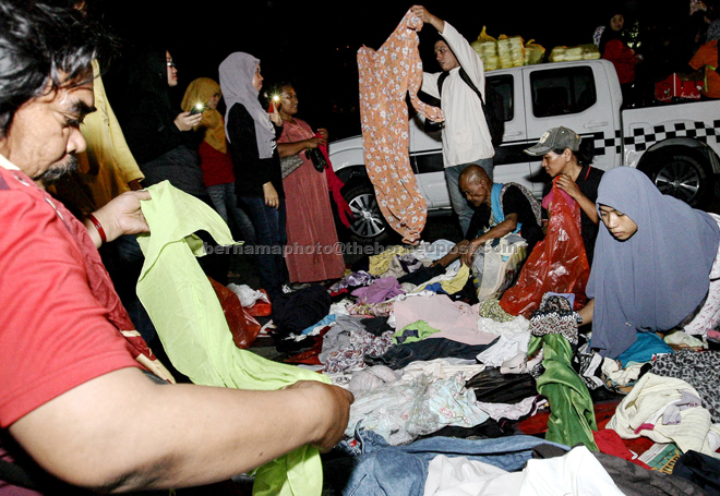 The homeless at Jalan Silang in Kuala Lumpur choosing donated used clothes during the Outreach Yayasan Salam Malaysia programme with NGOs. — Bernama photo