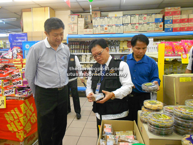 James (left) inspecting Raya cookies with his team at a supermarket.