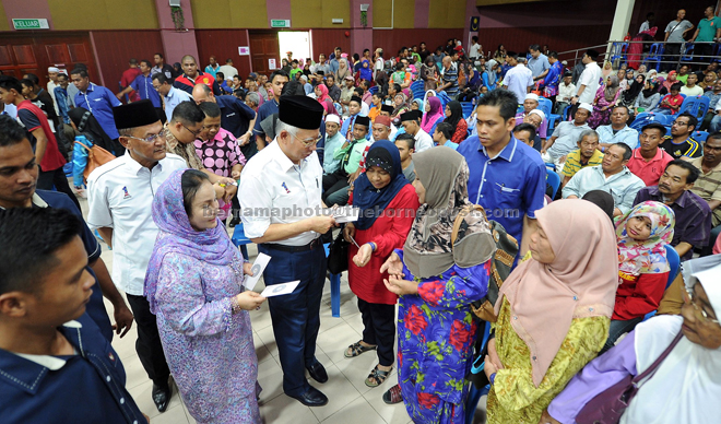 Najib and Rosmah present the zakat during a ceremony at the Sultan Ahmad Shah convention hall in Pekan, Pahang. — Bernama photo