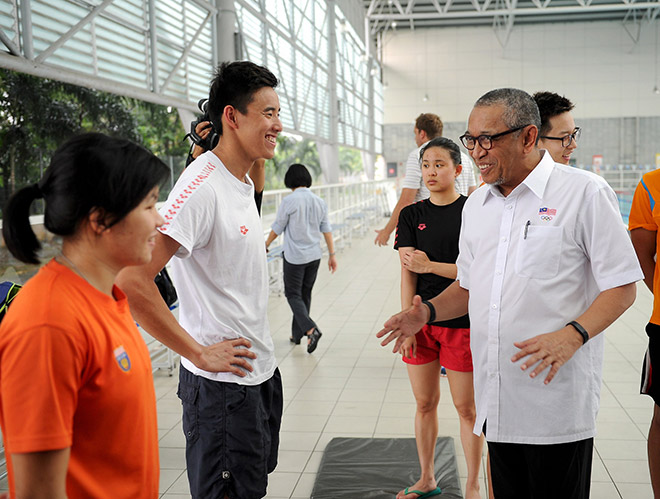 Al Amin talks with Welson Sim (second left) after observing the preparation of swimmers at Paralympic Centre of Excellence in Kampung Pandan. — Bernama photo