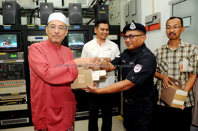Jailani (left) presenting the ‘sahur’ food packs to the TM staff. — Bernama photo