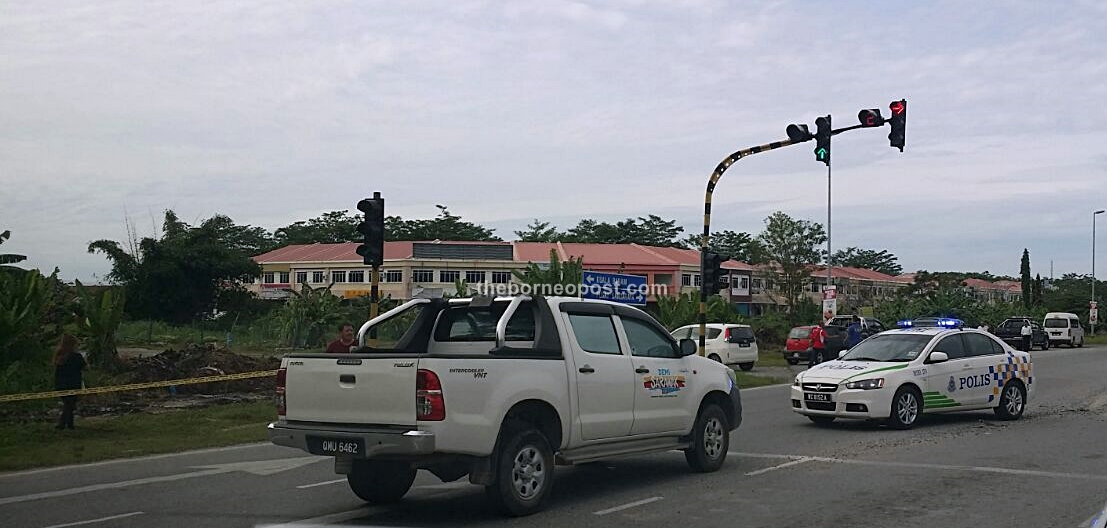 A police vehicle stops to investigate the shooting and the pickup truck where Bill Kayong was found dead in his seat.