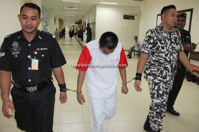 Tompo being escorted by Prisons Department officers at the courthouse.