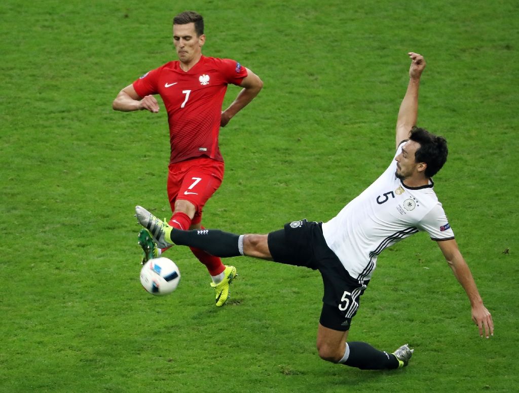 Poland's forward Arkadiusz Milik (L) vies for the ball against Germany's defender Mats Hummels during the Euro 2016 group C football match between Germany and Poland at the Stade de France stadium in Saint-Denis near Paris on June 16, 2016. Photo by AFP