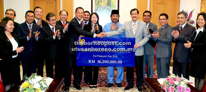 Vincent (left) presenting the RM16.2 million dividend to Pg Hassanel (right), witnessed by Musa (sixth right) and Linda (seventh right). 