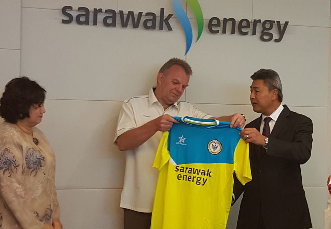 Sarawak Energy CEO Torstein (centre) receiving a training jersey emblazoned with his name from FAS chief Sudarsono while Aisah Eden looks on.