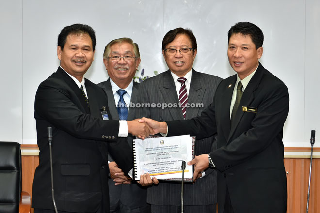 Kameri (right) hands over the working paper documents to Ik Pahon (left), witnessed by Abang Johari (third left) and Sikie.