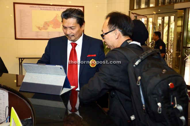 GETTING IT RIGHT: Muara Tuang assemblyman Dato Idris Buang sharing his notes with a reporter at the reception counter on the fifth day of the DUN Sitting yesterday. 