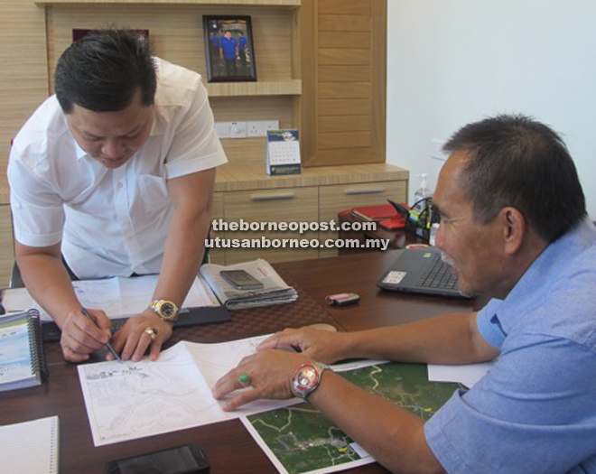 Len (right) and Huang discussing the alignment of the road linking Sarikei and Tanjong Manis.