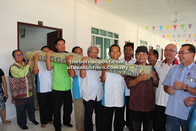 Masing (seventh from right) and other leaders carrying a local-made mat to symbolise the end of the ‘ngiling bidai’ ceremony at Rumah Akai yesterday.