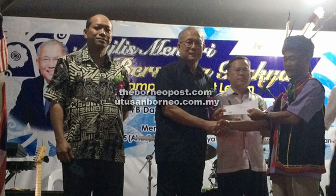 Riot (second left) presents a cheque from Datuk Seri Ahmad Zahid Hamidi’s special allocation to one of the village headmen, as Martin (second right) and political secretary to the Human Resources Minister Mejar (R) Peter Runin look on.