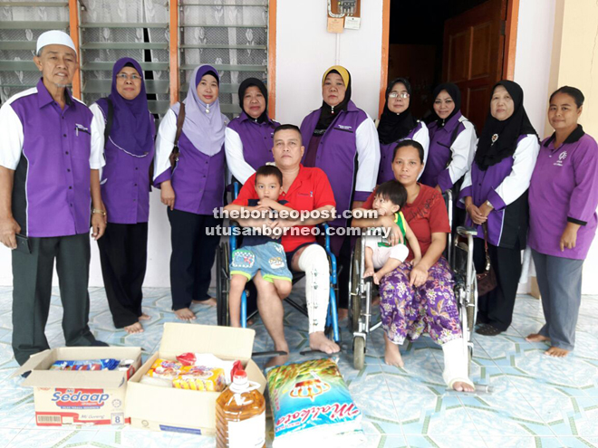 Nornni (standing fifth left) with committee members of Skuad Sayang N79 Bukit Kota with Joakim (seated left) and wife Mariati after handing over the donation.