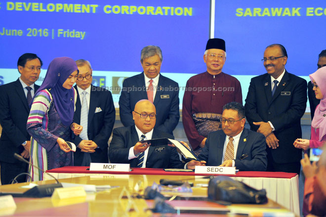 Najib (standing second right) and Ahmad Zahid (second right) witness the signing of the MoU for the BOET by Aminuddin (seated left) and Soedirman. — Bernama photo