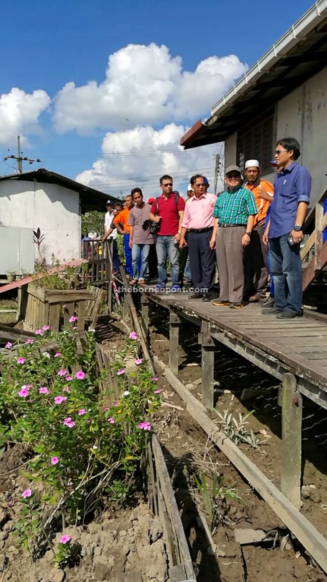 Uggah (second right) and Razi (right), accompanied by officers and villagers, inspecting SK Kampung Buda which was severely damaged by a landslide.
