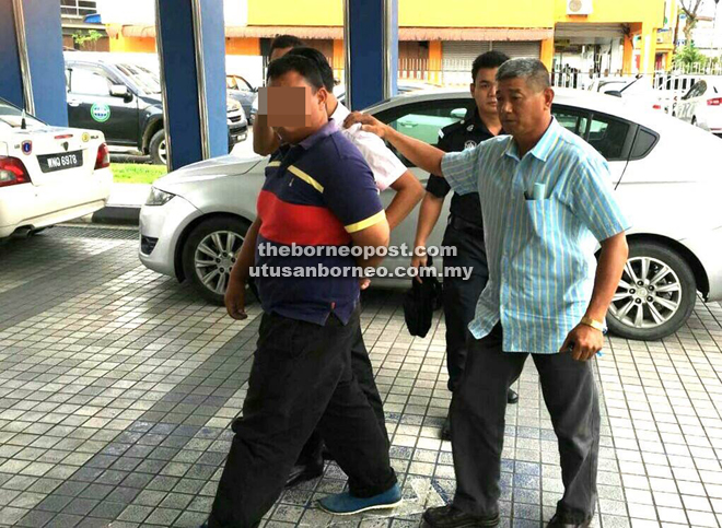 Policemen escorting the suspects to assist in investigations into the Labuan offshore job scam.